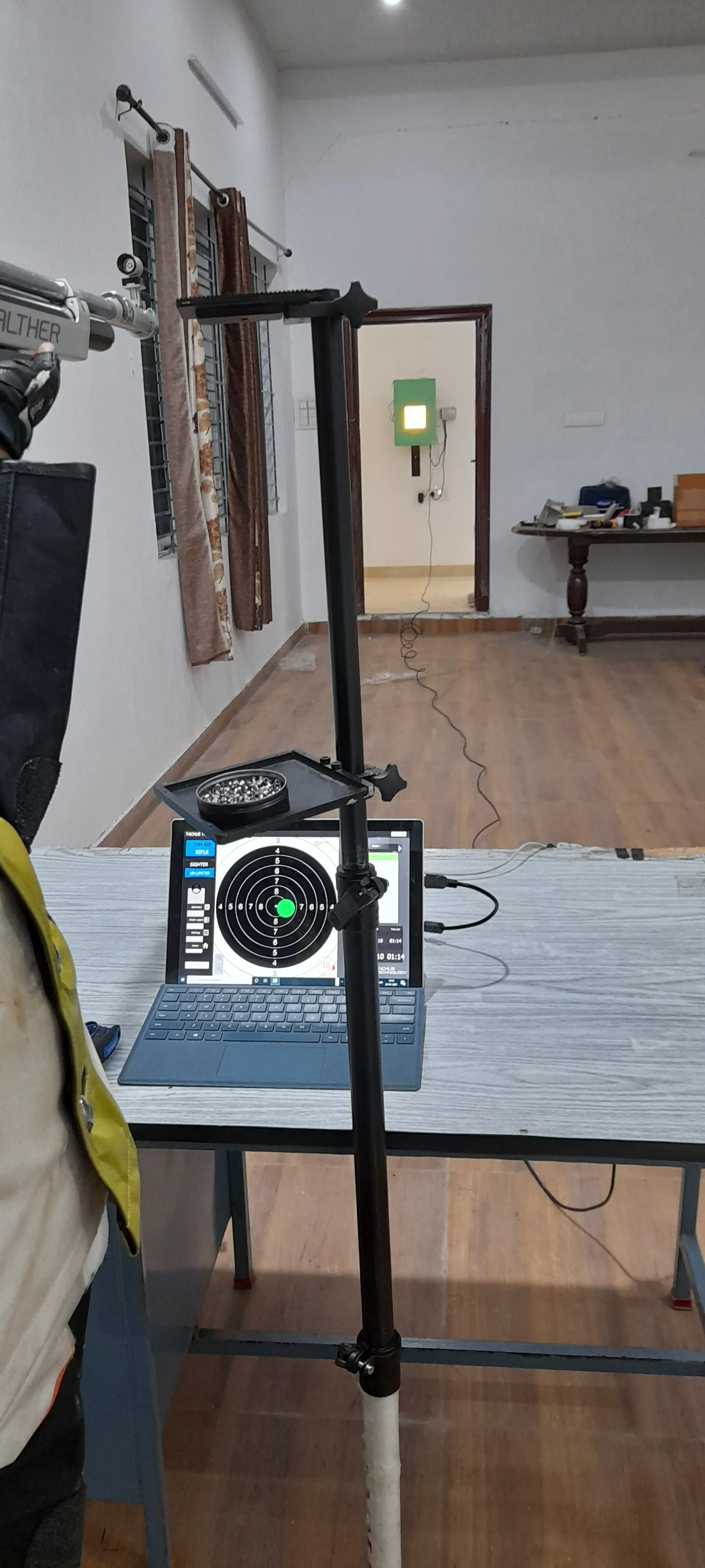 Air rifle shooter training on a Tachus 10 home lane with the scoring laptop