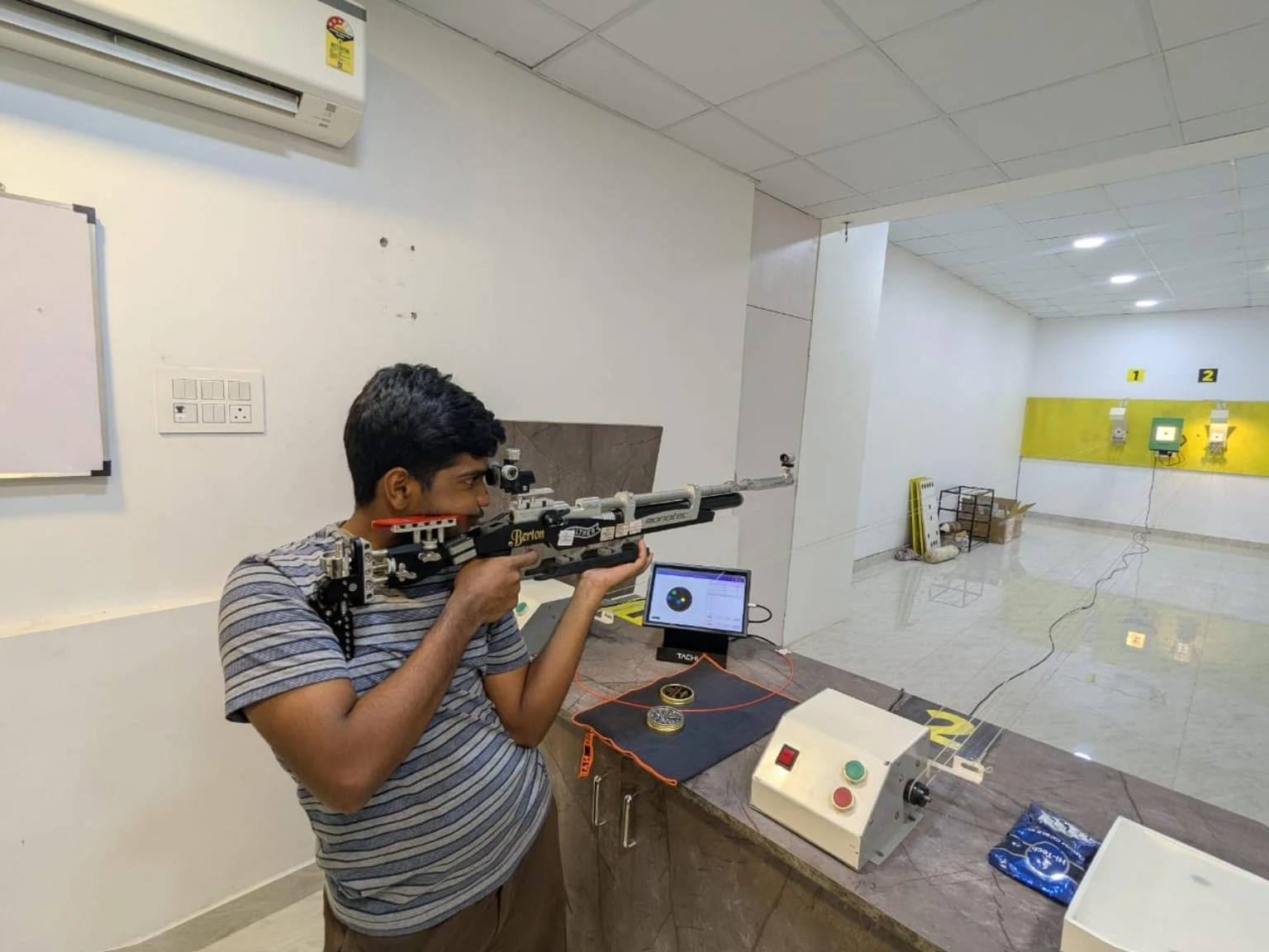 Air rifle athlete training with live Tachus scoring on the lane monitor