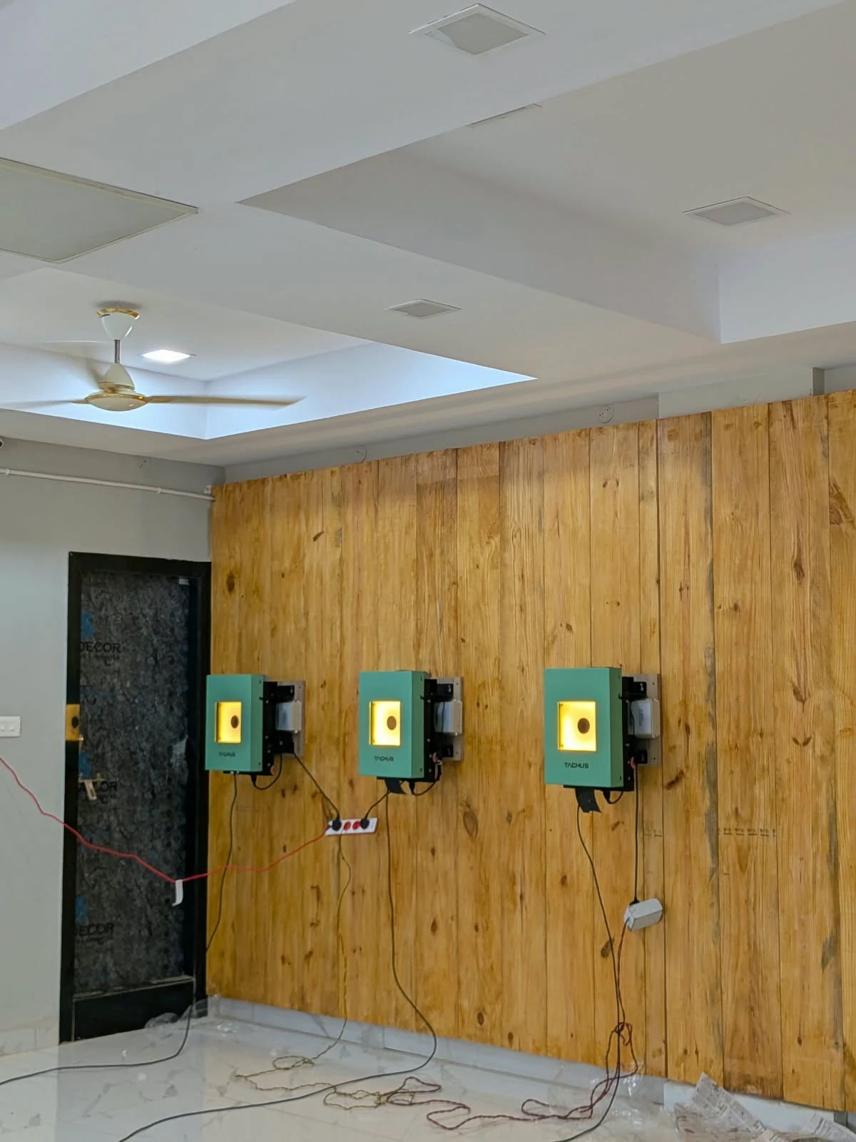 Illuminated Tachus electronic targets mounted along a wooden indoor range wall